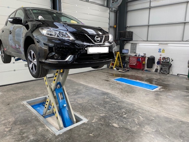 Recessed low profile scissor lift with a car on